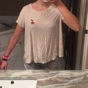 Neutral colored t shirt with cherry embroidery.